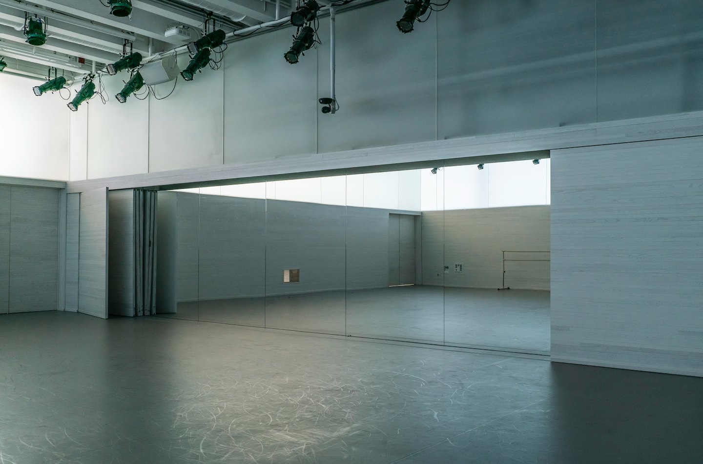 Sala da ballo vuota con parete a specchio e sbarra per balletto.